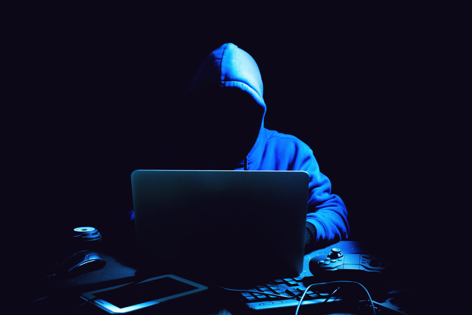 A person in a hooded jacket using a laptop.