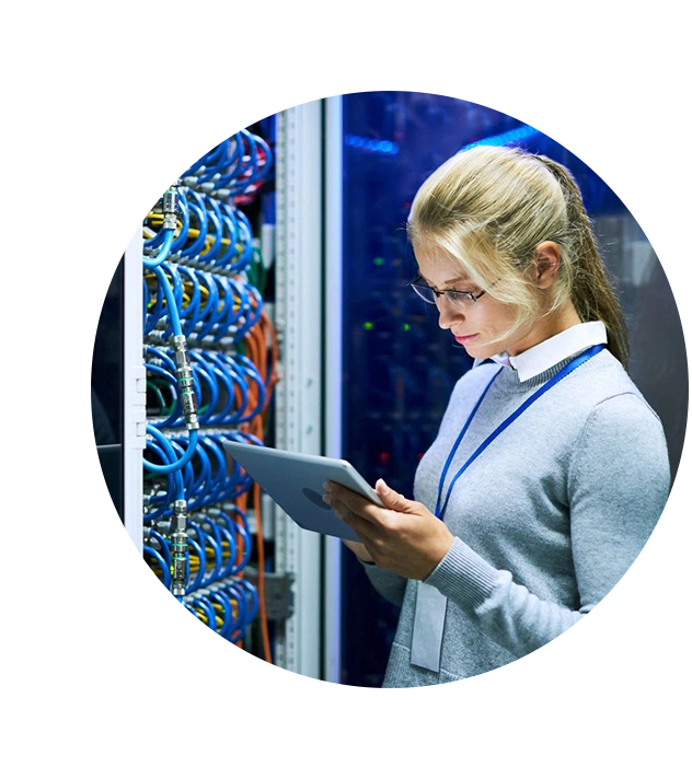 A woman is holding a tablet in front of a server rack.